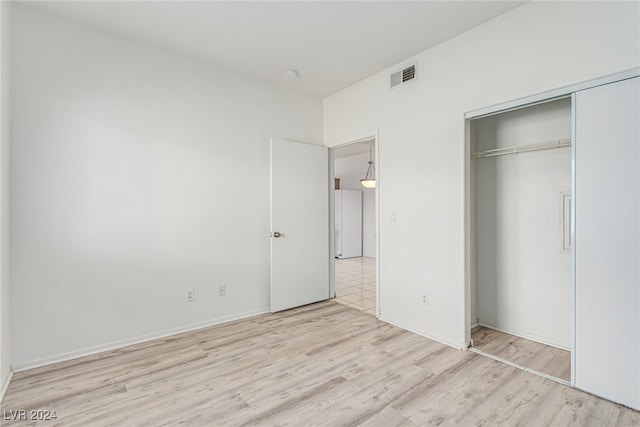 unfurnished bedroom featuring a closet and light hardwood / wood-style flooring