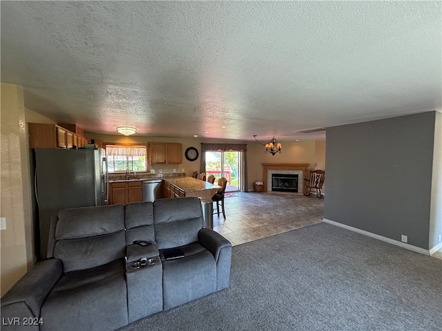 carpeted living room with a tiled fireplace, a textured ceiling, and sink