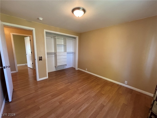 unfurnished bedroom featuring wood-type flooring and a closet