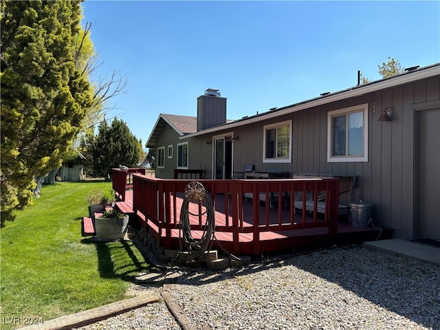 back of house with a deck and a lawn