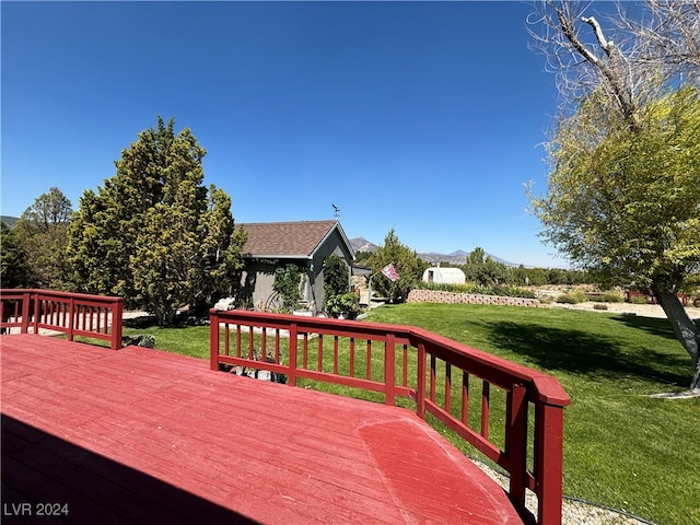 wooden terrace featuring a lawn