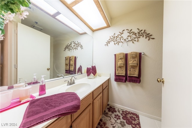 bathroom with vanity, tile patterned floors, and a skylight