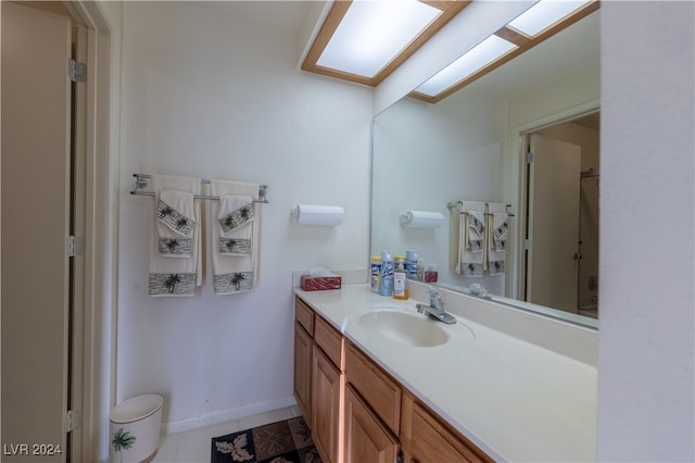 bathroom with vanity, tile patterned floors, and a skylight