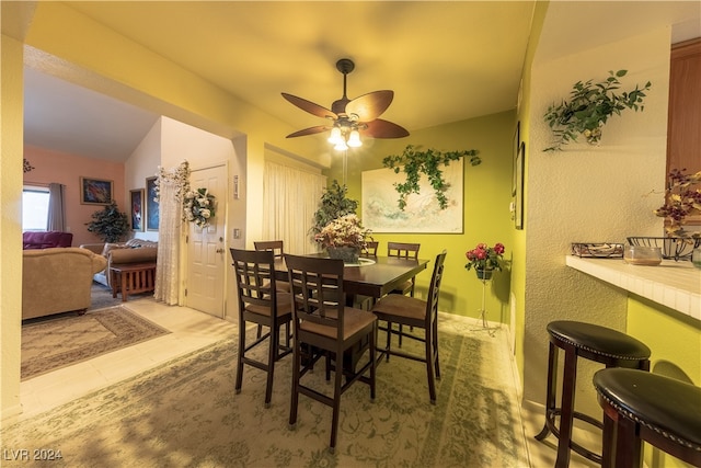 dining room featuring light tile patterned flooring, vaulted ceiling, and ceiling fan