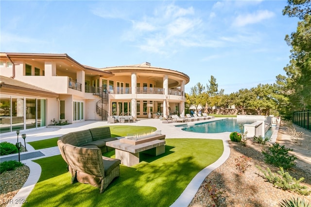 back of property with a patio, a yard, and a balcony