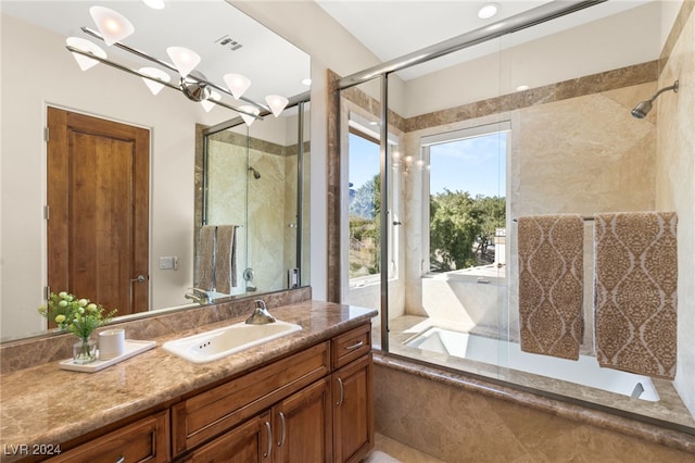 bathroom with vanity, a notable chandelier, and shower with separate bathtub