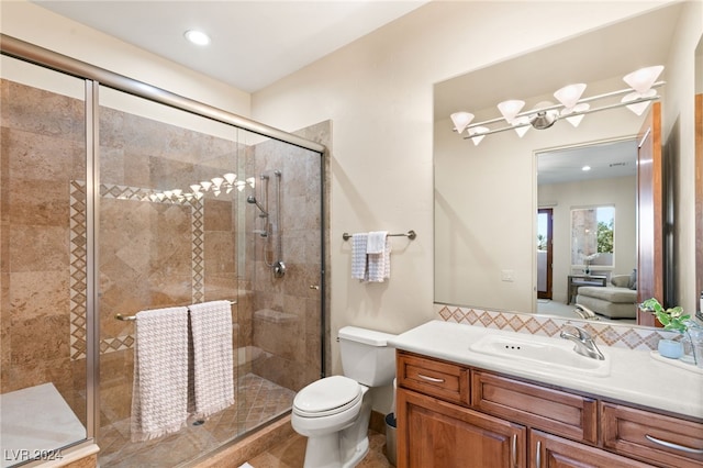 bathroom featuring toilet, an enclosed shower, and vanity