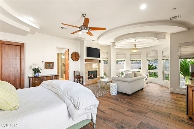 bedroom with dark hardwood / wood-style floors, a fireplace, and ceiling fan