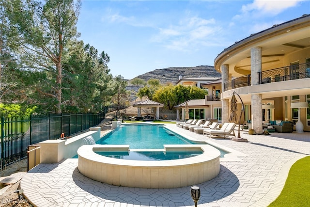 view of pool with a gazebo, an outdoor living space, a patio area, a mountain view, and an in ground hot tub