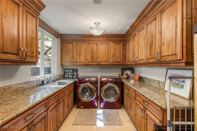 laundry room with sink, light tile patterned flooring, separate washer and dryer, and cabinets