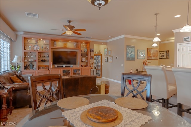 tiled dining room with ornamental molding and ceiling fan