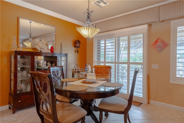 tiled dining space featuring crown molding and a wealth of natural light