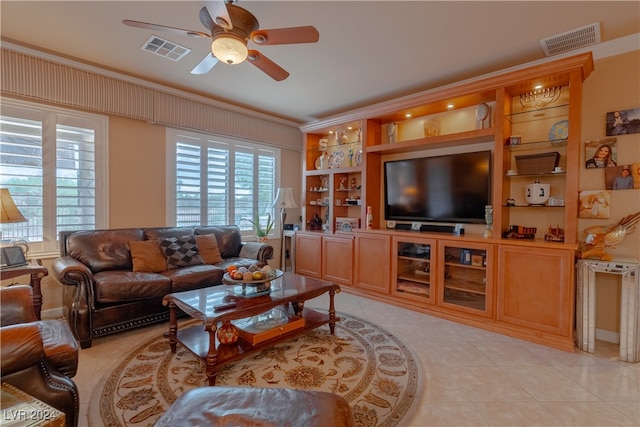 tiled living room featuring crown molding, built in features, and ceiling fan