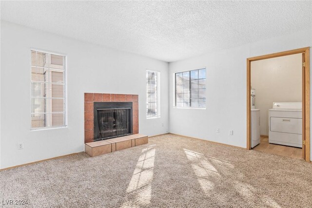 unfurnished living room featuring a textured ceiling, light colored carpet, and a fireplace