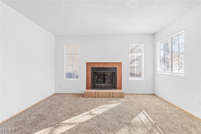 unfurnished living room with carpet, a textured ceiling, and a fireplace