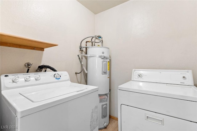 laundry area with water heater, laundry area, independent washer and dryer, and light wood-style floors