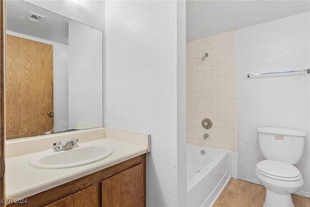 bathroom featuring shower / tub combination, toilet, wood finished floors, vanity, and visible vents