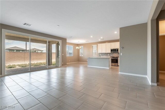 unfurnished living room with an inviting chandelier