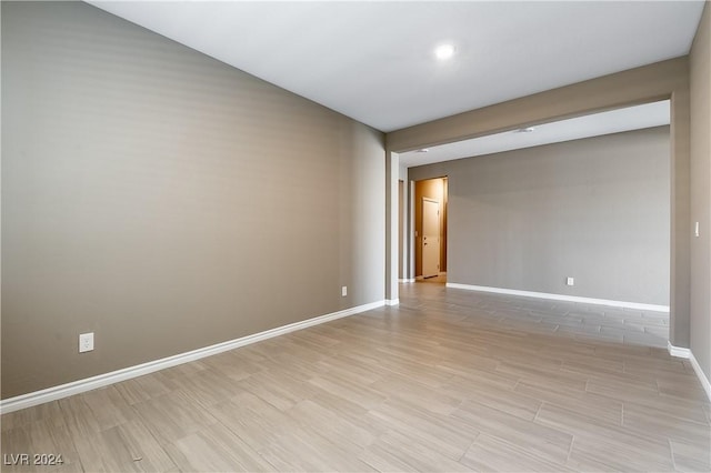 spare room with light wood-type flooring and baseboards