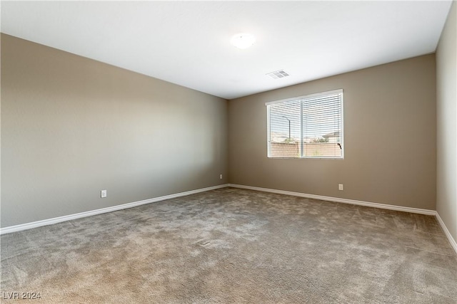 spare room with baseboards, visible vents, and carpet flooring