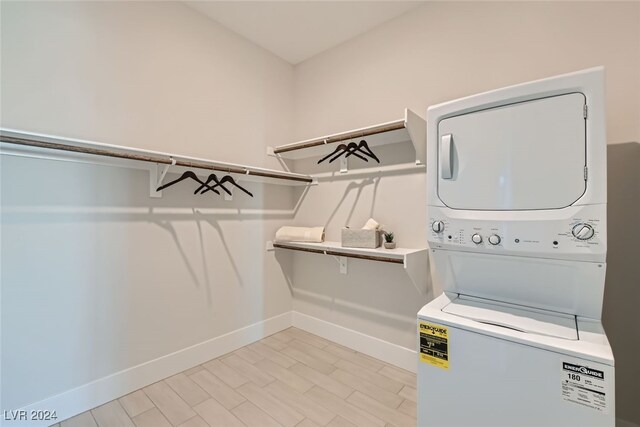 washroom featuring stacked washer / drying machine and light wood-type flooring