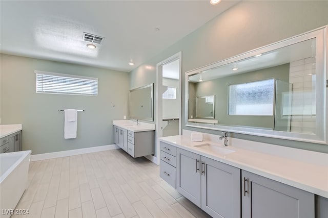 bathroom featuring vanity, hardwood / wood-style flooring, and a bath