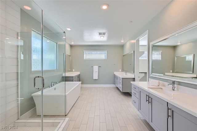 bathroom with vanity and shower with separate bathtub