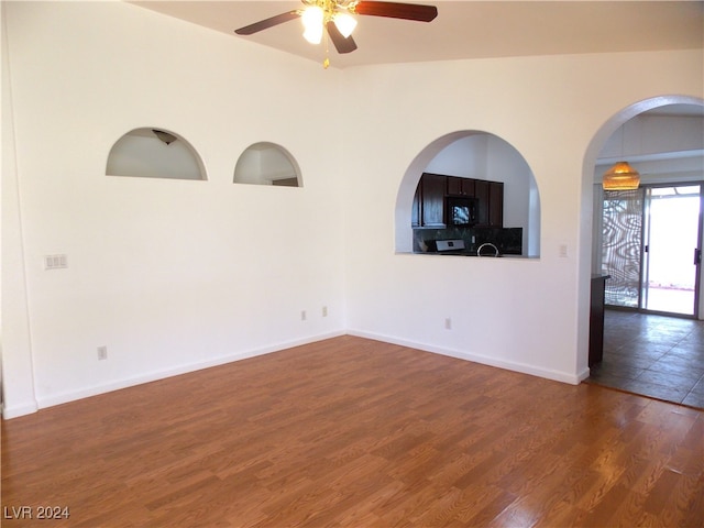 empty room featuring ceiling fan, lofted ceiling, and dark hardwood / wood-style flooring