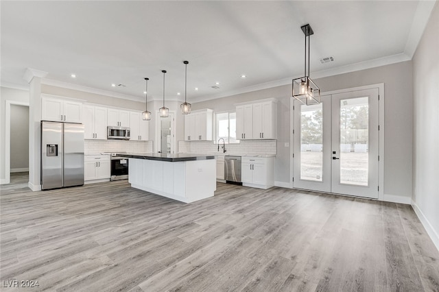 kitchen featuring pendant lighting, white cabinetry, light hardwood / wood-style flooring, and stainless steel appliances