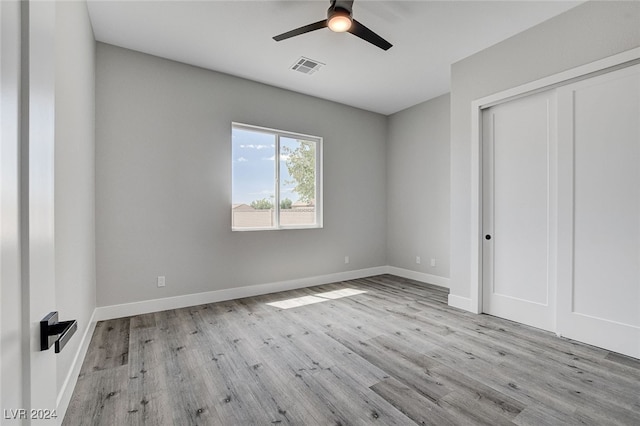 unfurnished bedroom with a closet, light wood-type flooring, and ceiling fan