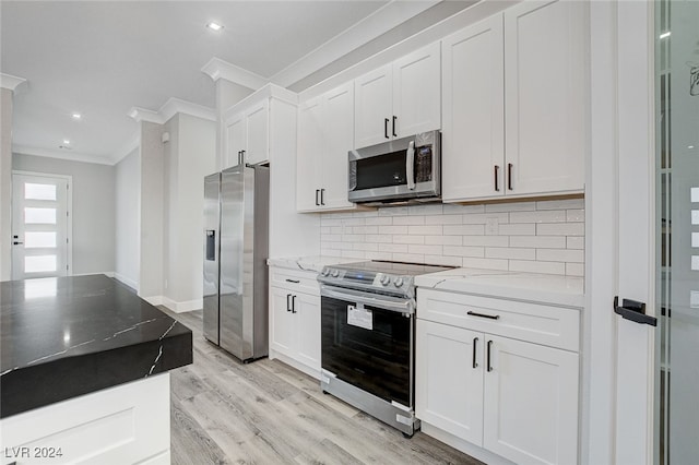 kitchen featuring light stone countertops, white cabinetry, stainless steel appliances, and light wood-type flooring