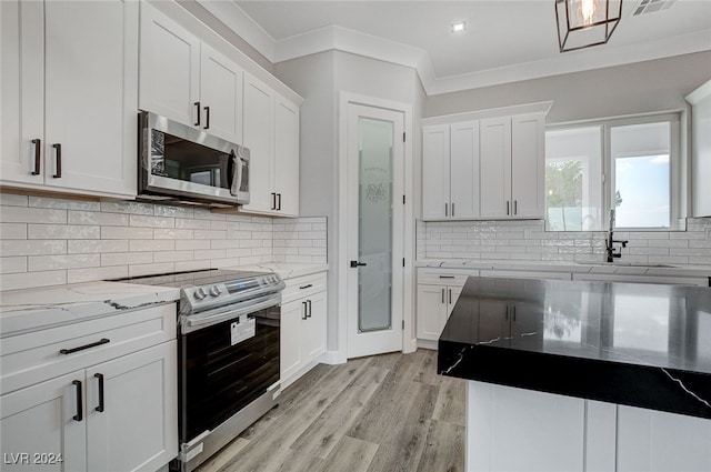 kitchen with appliances with stainless steel finishes, light wood-type flooring, and white cabinets