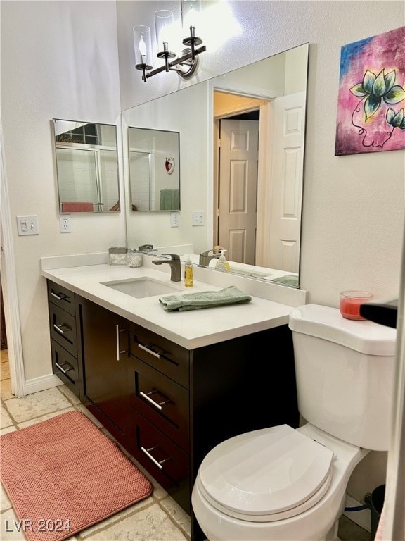 bathroom with toilet, vanity, and an inviting chandelier