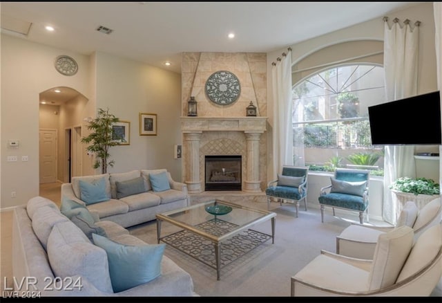 living room with a tiled fireplace and carpet floors