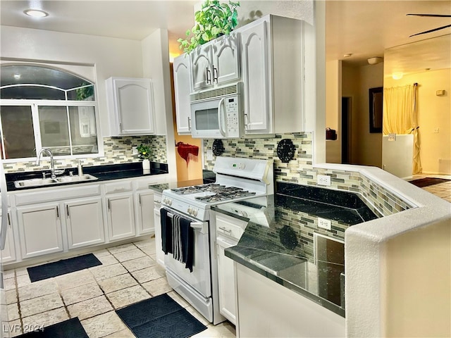 kitchen with white appliances, white cabinetry, sink, and tasteful backsplash