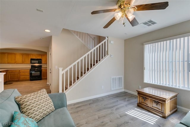 living room with ceiling fan and light hardwood / wood-style flooring