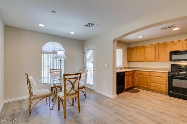 kitchen featuring sink, light hardwood / wood-style floors, and black appliances