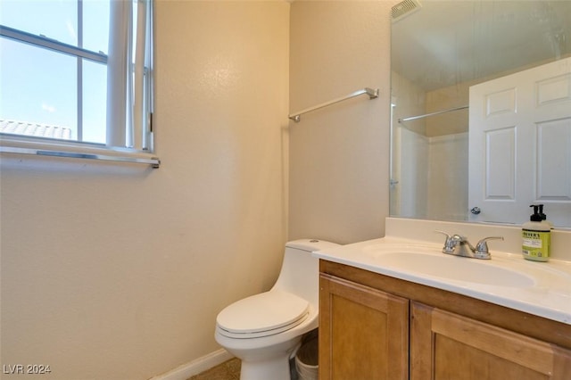 bathroom with walk in shower, vanity, and toilet