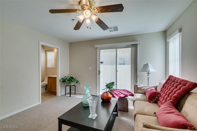 living room with ceiling fan, light colored carpet, and plenty of natural light