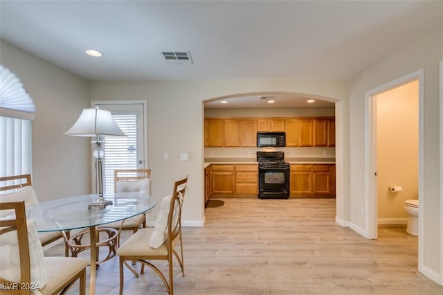 kitchen with light hardwood / wood-style flooring and black appliances