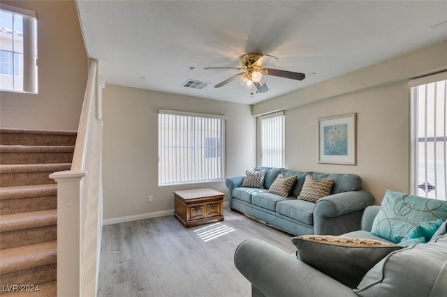 living room featuring ceiling fan, a healthy amount of sunlight, and light wood-type flooring