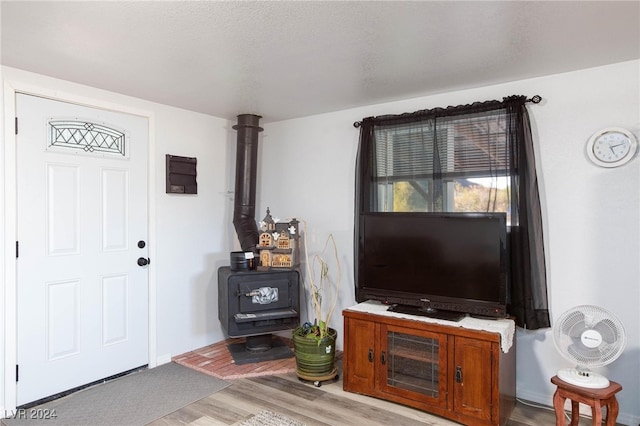 living room with light hardwood / wood-style floors and a wood stove