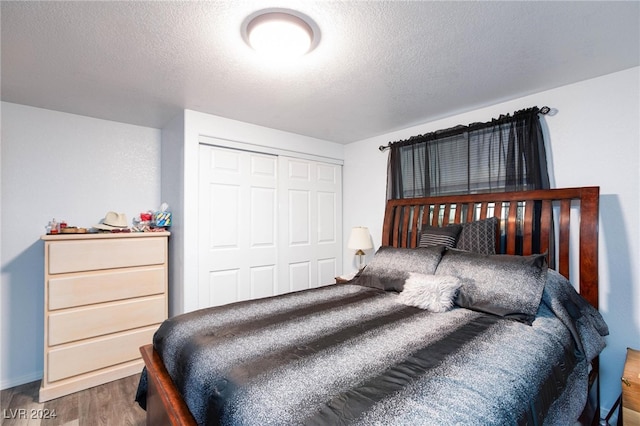 bedroom featuring a textured ceiling, hardwood / wood-style flooring, and a closet