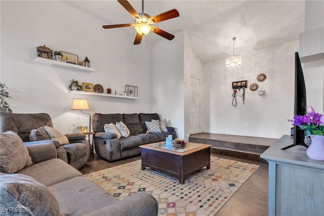 living room featuring ceiling fan with notable chandelier, dark hardwood / wood-style floors, and high vaulted ceiling