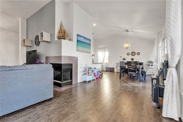 living room featuring a multi sided fireplace, dark hardwood / wood-style flooring, a chandelier, and lofted ceiling