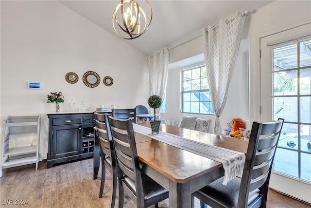 dining room featuring a chandelier, wood-type flooring, and lofted ceiling