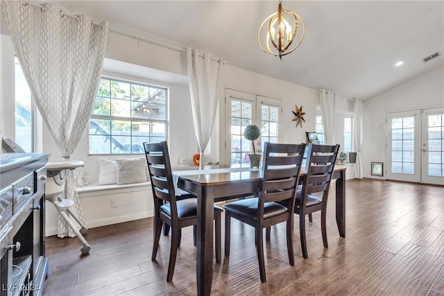 dining space with dark wood-type flooring, lofted ceiling, and an inviting chandelier