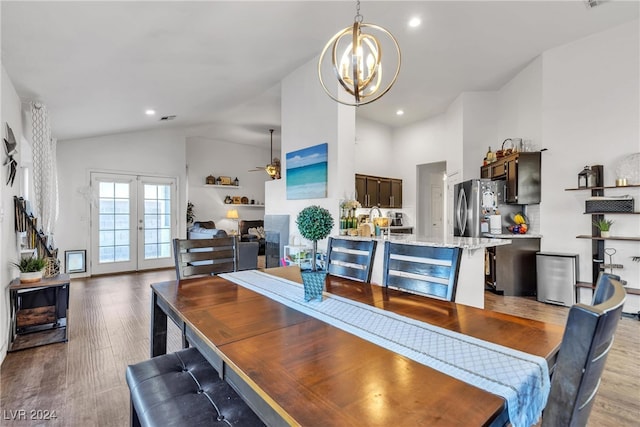 dining area with ceiling fan with notable chandelier, light hardwood / wood-style floors, and lofted ceiling