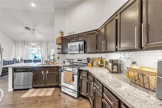 kitchen featuring pendant lighting, sink, dark hardwood / wood-style floors, appliances with stainless steel finishes, and tasteful backsplash