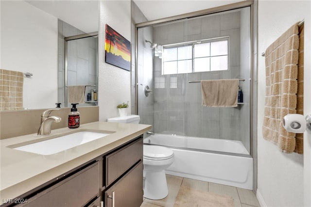 full bathroom featuring tile patterned floors, vanity, toilet, and shower / bath combination with glass door